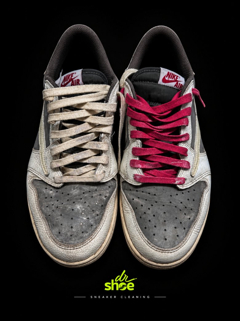 A grey and white Air Jordan 1 Low, soiled with dulled laces, before cleaning